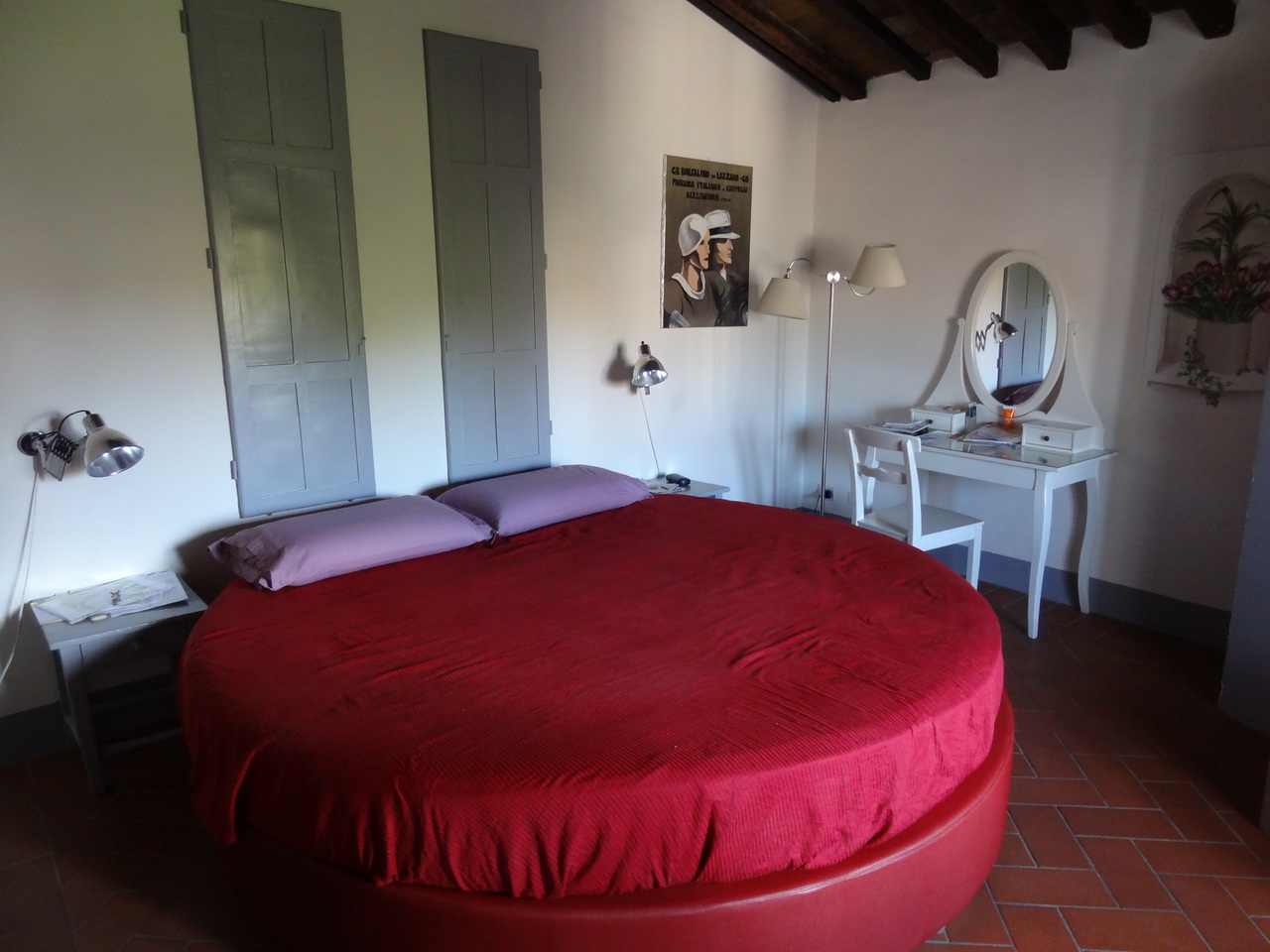 Красная круглая кровать с сиреневыми подушками