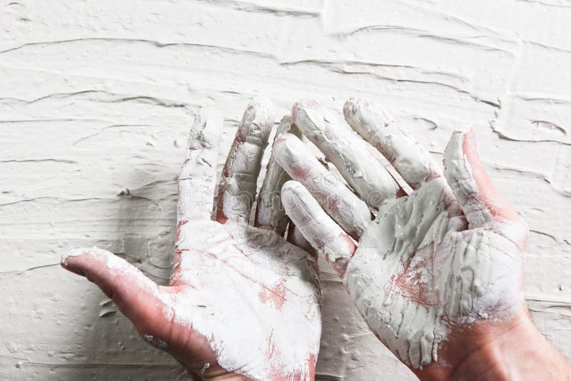 Builder hands in wet white plaster on stucco wall. Builder Hand White Plaster Stucco Wall Worker Flat Lay Construction Repair Concept stock image