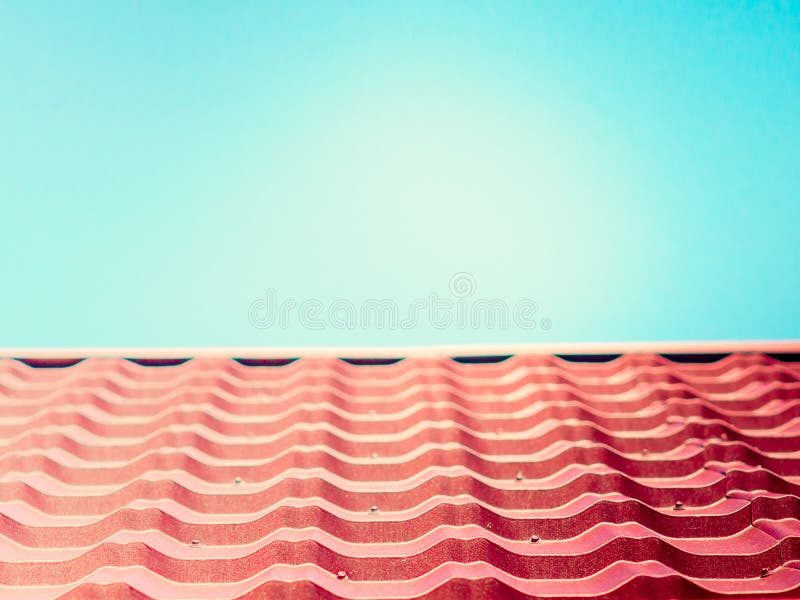 Close-up of pink roof texture tile with blue sky royalty free stock image