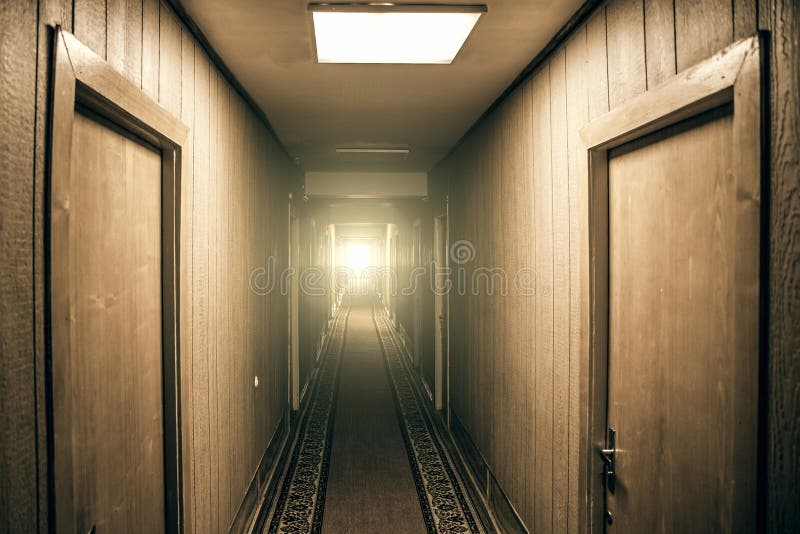 Empty corridor in apartment building with doors and light in the end of hall, perspective royalty free stock images