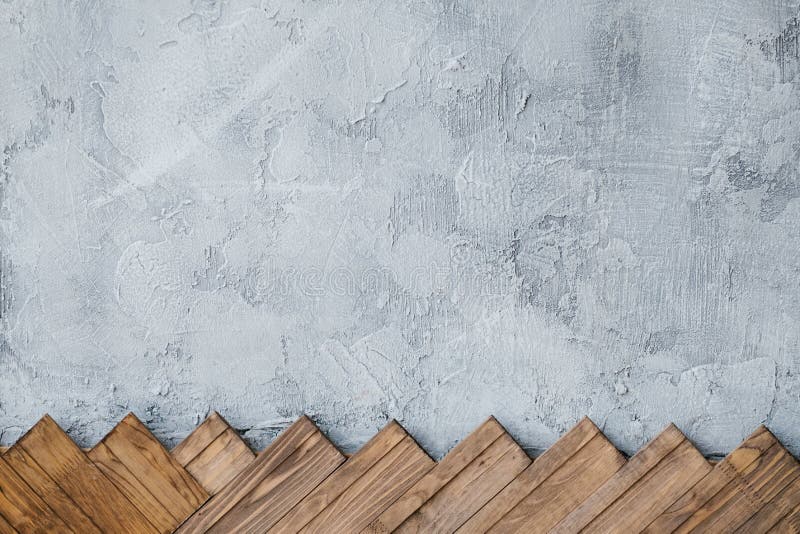 Gray stucco plaster wall background wood planks. Gray stucco plaster wall background. arranged row of wood planks at the bottom royalty free stock images