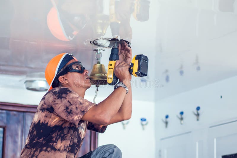 A handyman working with power saw. A worker sawing a hole in ceiling royalty free stock image