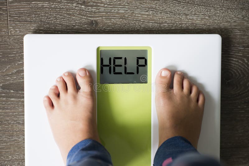 Help your child to have a healthy diet and lifestyle, with obese kid feet on weight scale, under the supervision of the mother. Help your child to have a healthy royalty free stock photo