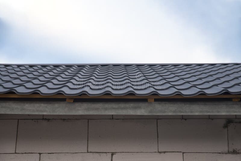 The metal tile on the roof of the house is gray royalty free stock images