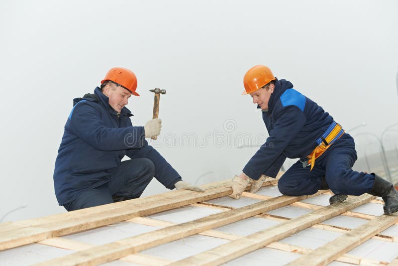 Roofing workers hammer roof boarding royalty free stock images