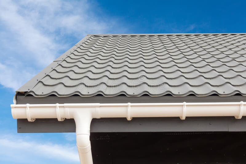 SIP panel house construction. New gray metal tile roof with white rain gutter. royalty free stock image