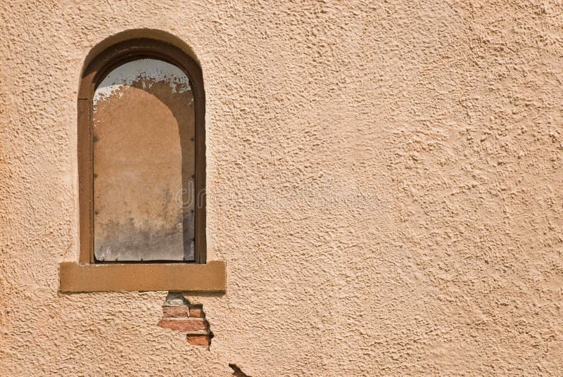 Stucco Wall. Brown stucco wall and arched window royalty free stock photo