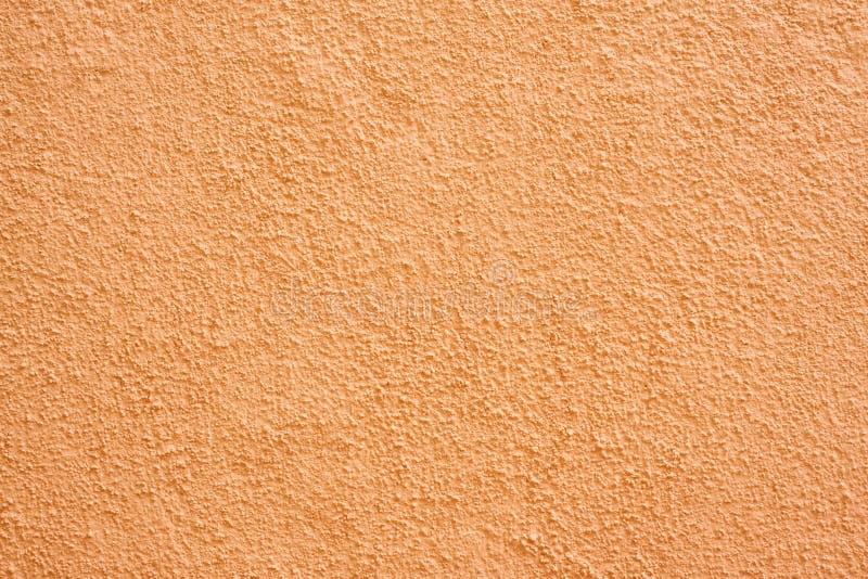 Stucco wall. Orange stucco textured wall background with natural light royalty free stock photography