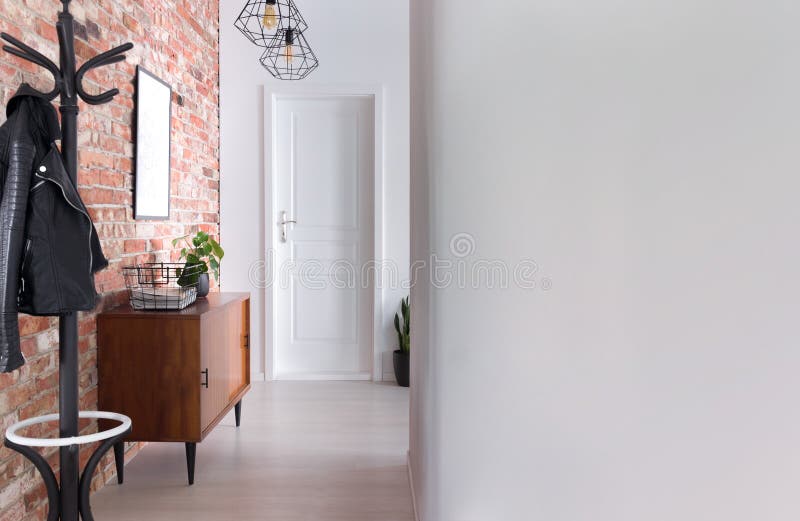 Stylish apartment hall clothes hanger, cupboard and brick wall, real photo stock photo