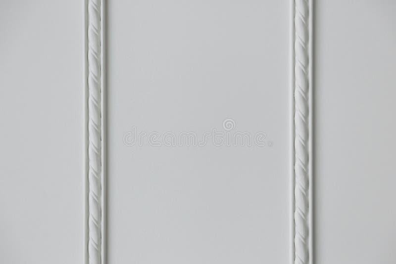 Two strips of stucco molding on a white wall. Two strips of embossed stucco molding on a white wall, close up royalty free stock images