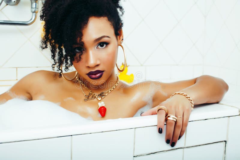 Young pretty african american girl taking bath with foam, lifestyle people concept. Closeup royalty free stock photography