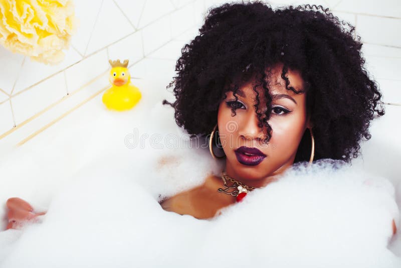Young pretty african american girl taking bath with foam, lifestyle people concept. Closeup royalty free stock photos